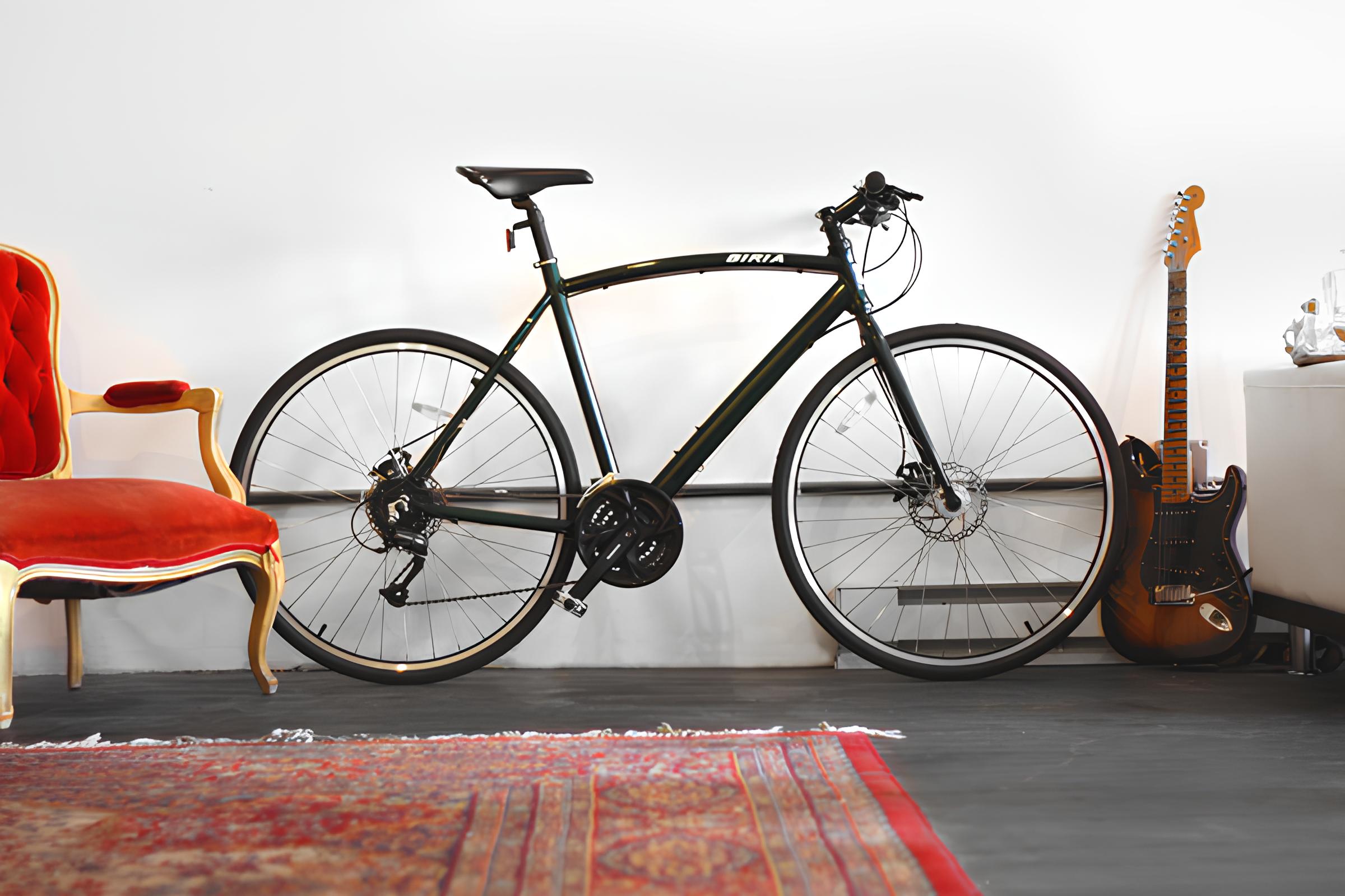 An image of a bicycle in a room in front of a white wall.