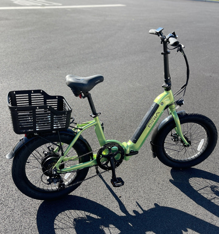 Plastic bike basket attached to rear wheel of bike on pavement